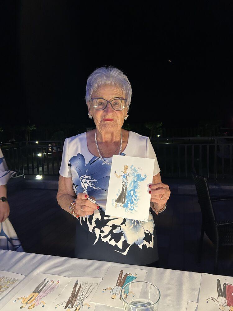Gościni wesela prezentuje swój portret namalowany na żywo przy stole