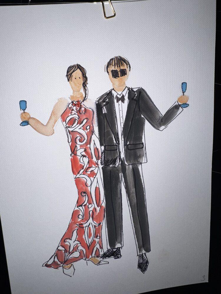 Portret pary gości: czerwona wzorzysta suknia i czarny smoking