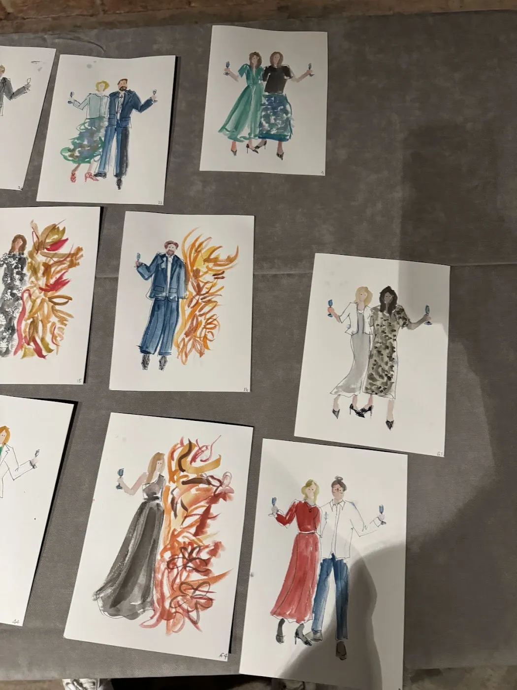 Gotowe akwarelowe ilustracje gości weselnych schnące na stole w Forcie Kręglickich