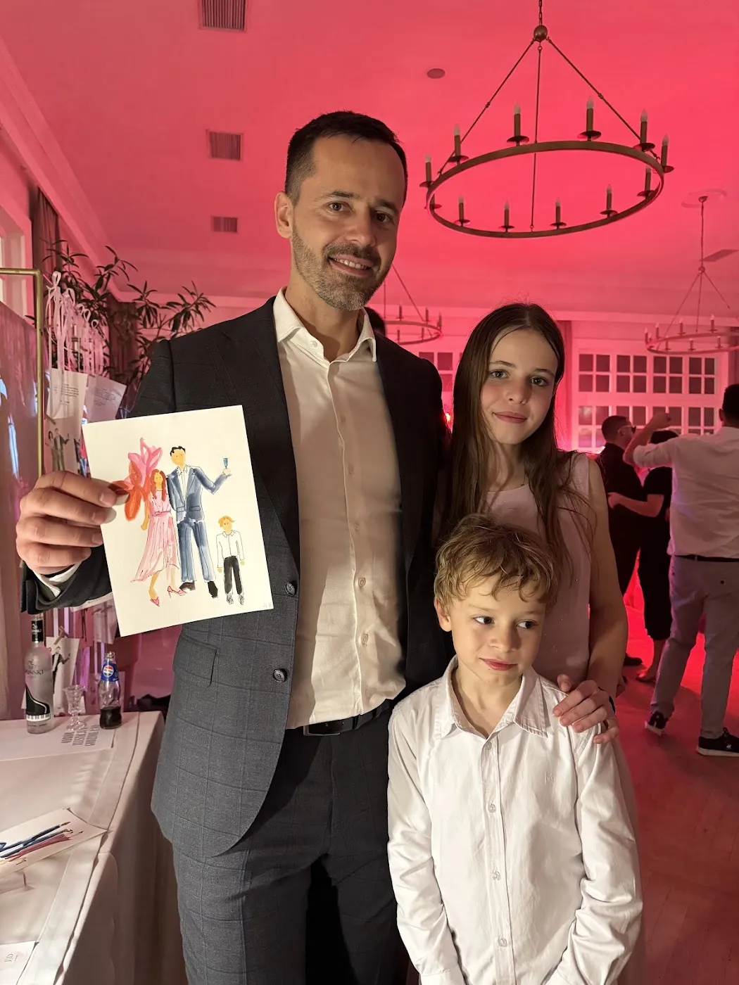 Mężczyzna z dwojgiem dzieci pokazuje swoją akwarelową ilustrację