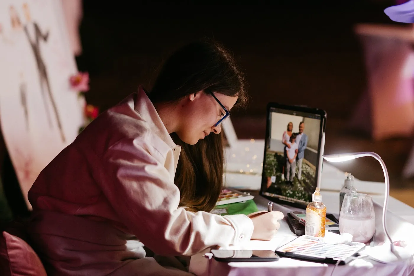 Artystka maluje portret gości na podstawie zdjęcia z tabletu w Pałacu Mierzęcin