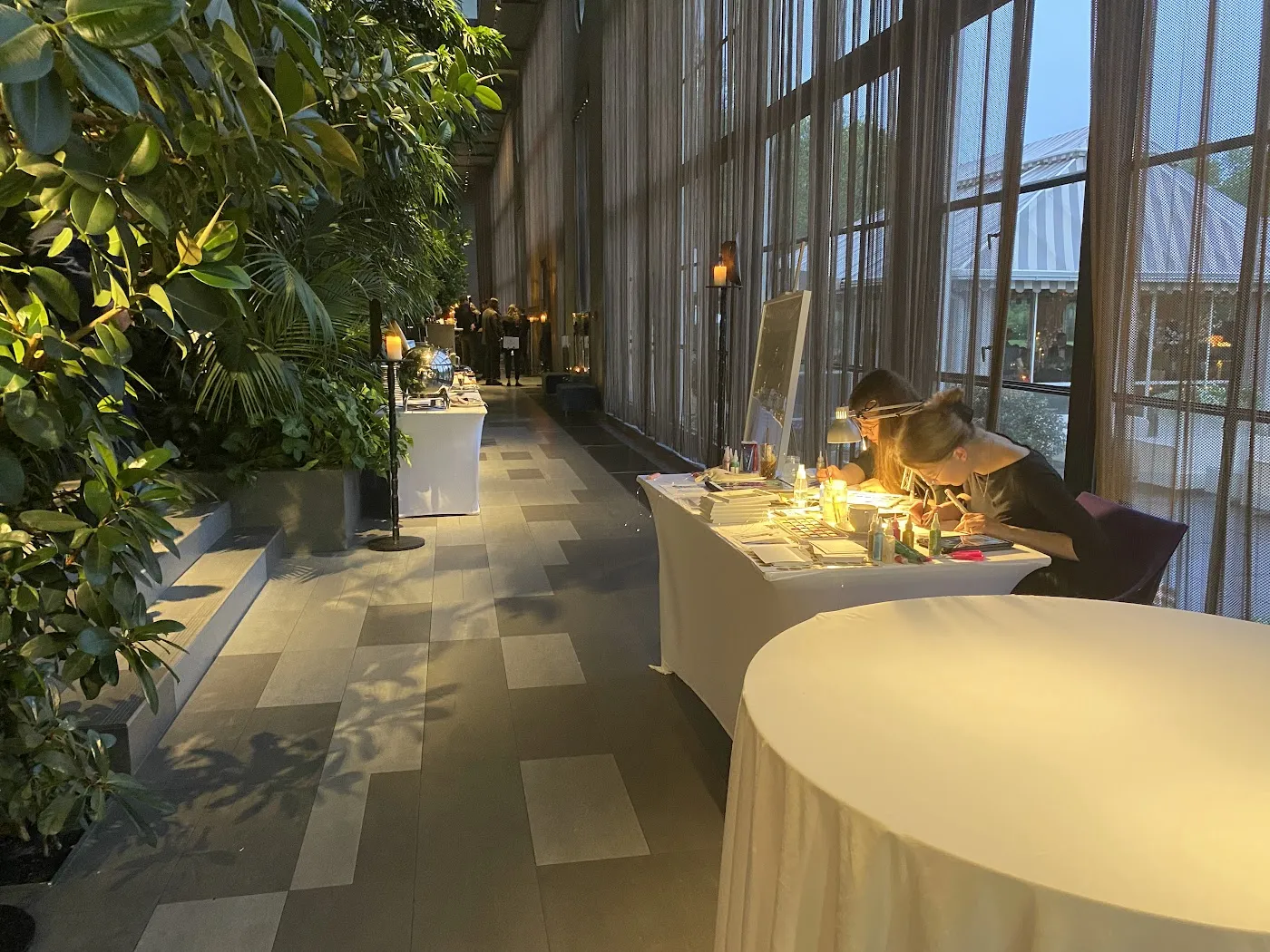 Artystki malują przy stanowisku w przeszklonej galerii Restauracji Belvedere