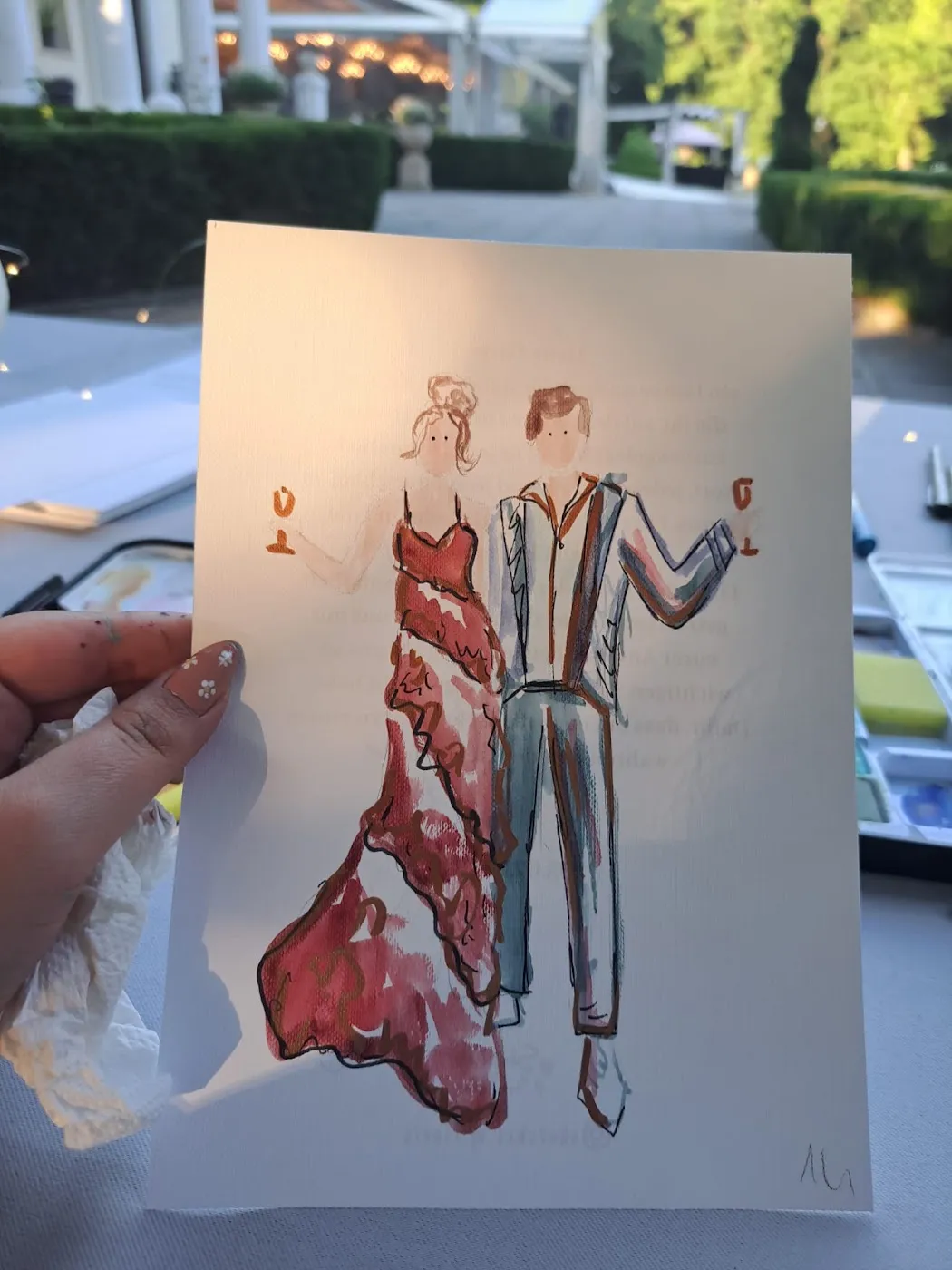 Akwarelowy portret pary w czerwonej sukni i garniturze trzymany pod światło