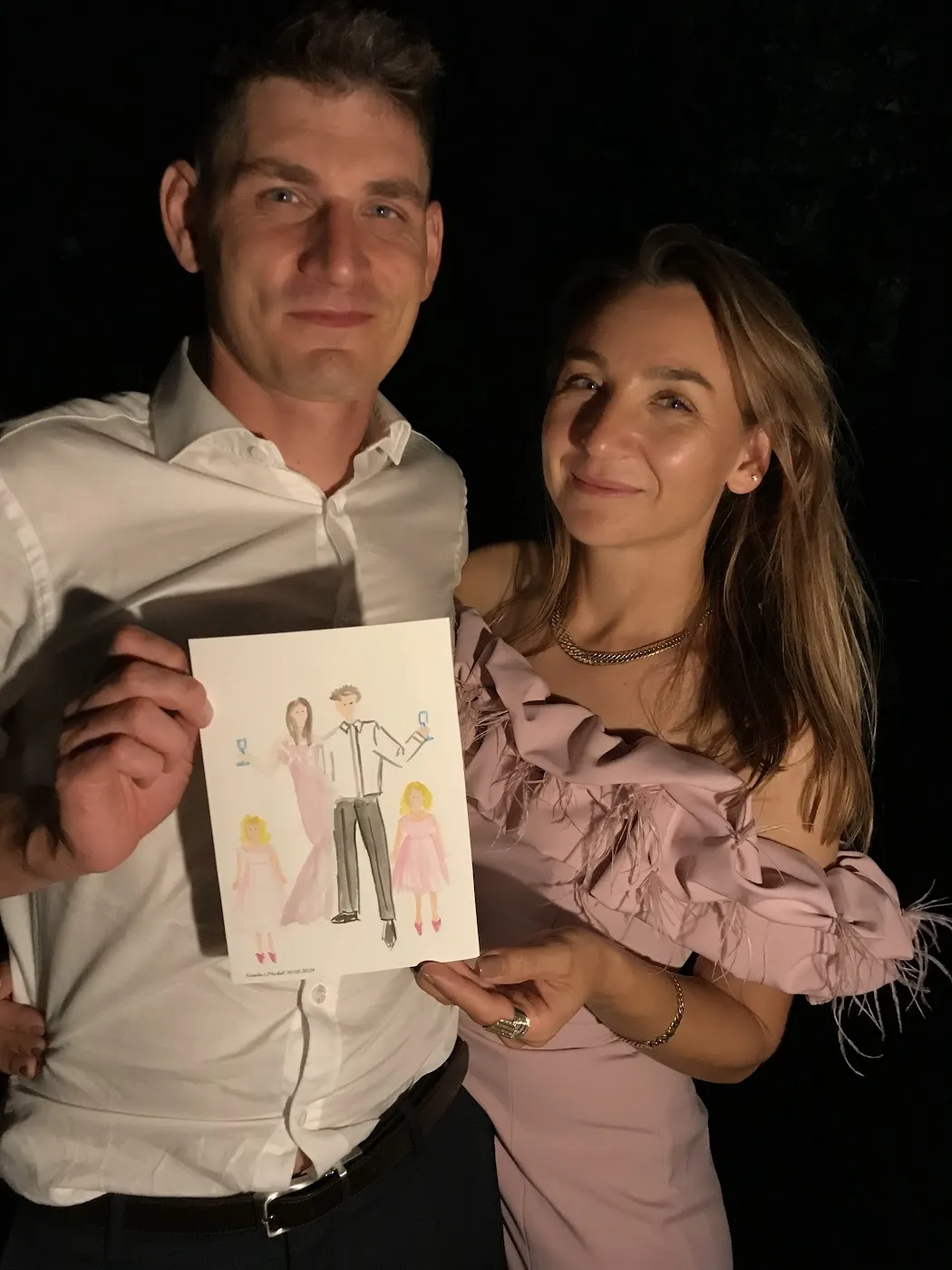 Para gości nocą pokazuje swoją akwarelową ilustrację w Villi Julianów